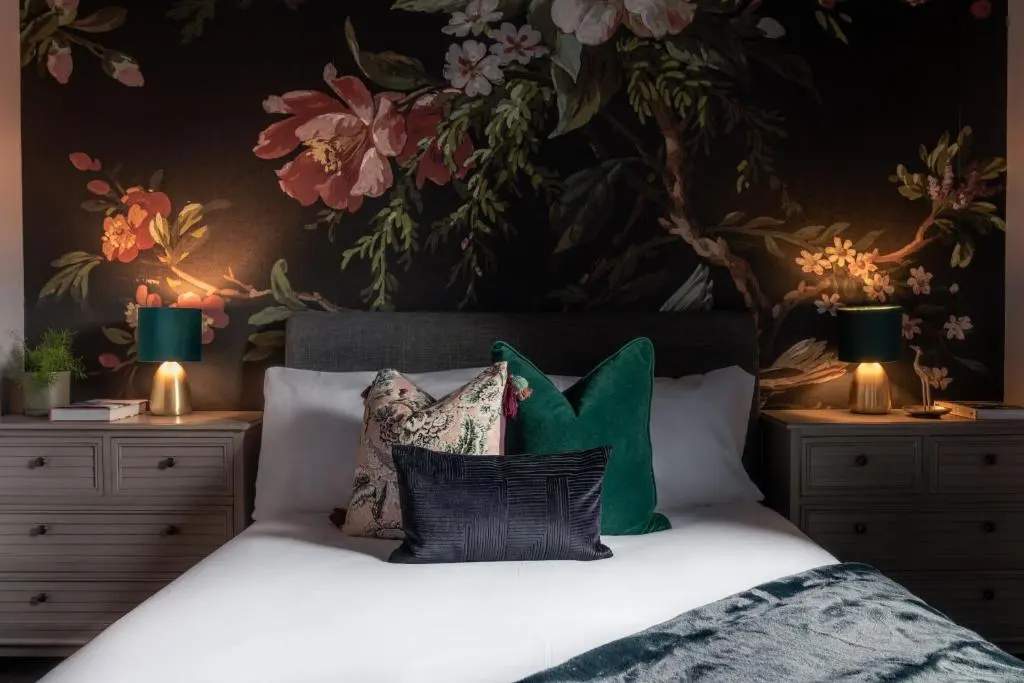 a bedroom with a large bed with a floral wallpaper at The Nessting Place in Inverness