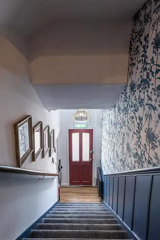 a stairway with a red door and a red wall at The Nessting Place in Inverness