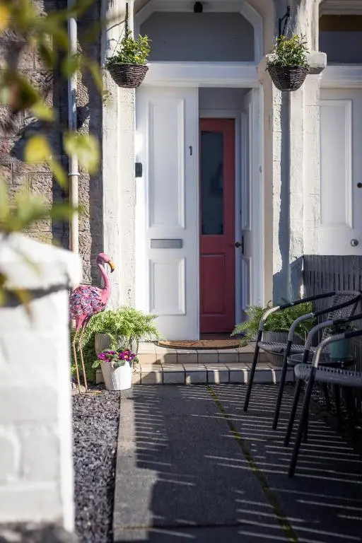 a pink flamingo standing in front of a door at The Nessting Place in Inverness