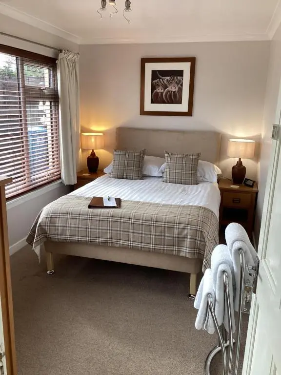 a bedroom with a bed and a window at Furan GuestHouse in Inverness