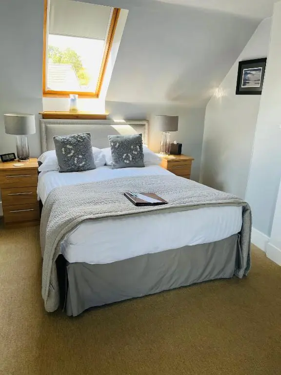 a bedroom with a large bed with a window at Furan GuestHouse in Inverness
