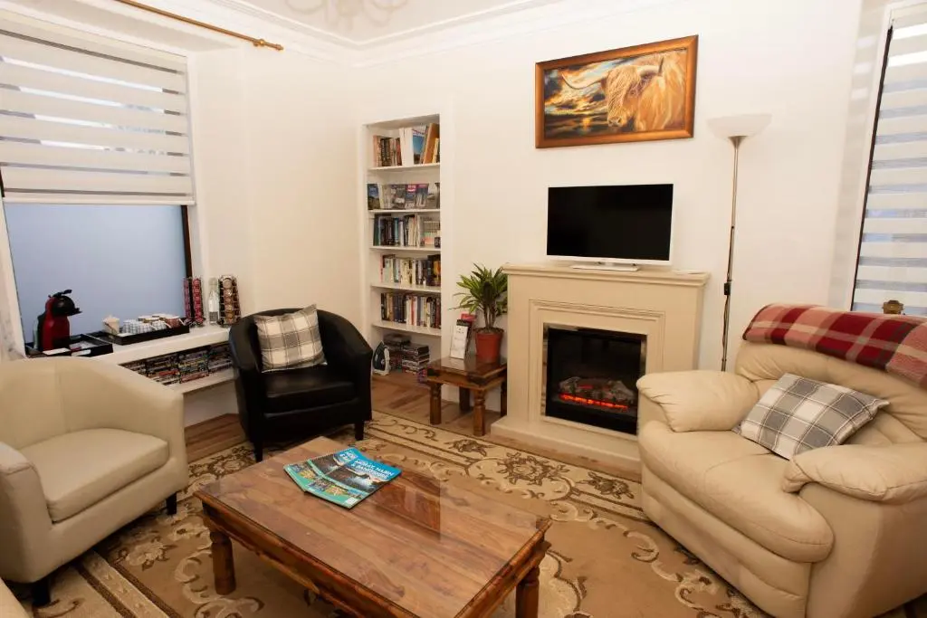 a living room with two chairs and a fireplace at Dunvegan Bed & Breakfast in Dufftown