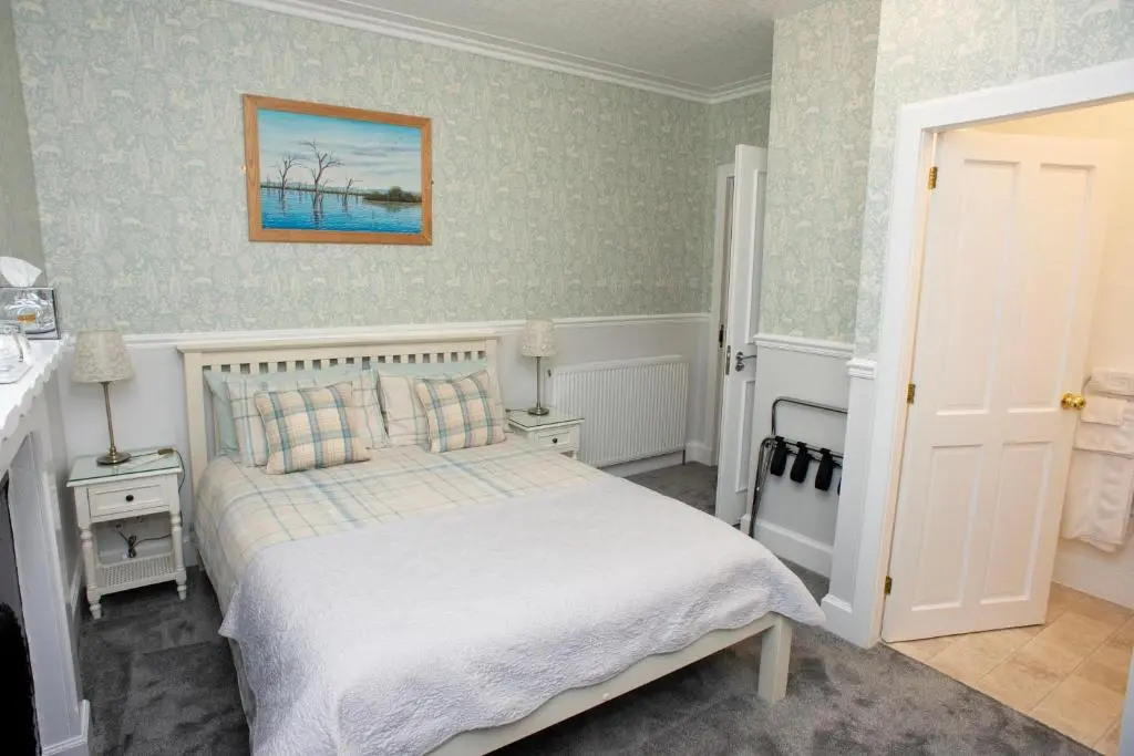 a bedroom with a bed and a painting on the wall at Dunvegan Bed & Breakfast in Dufftown
