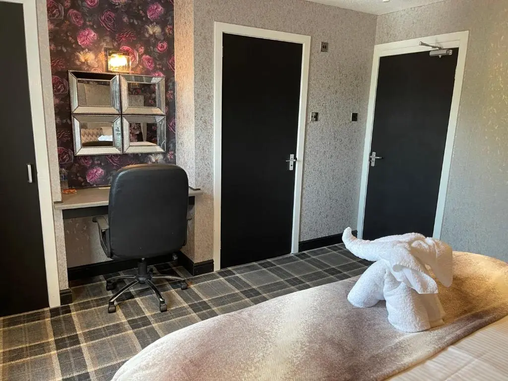 a bedroom with a bed with a stuffed elephant on the bed at The Albert Inn in Nairn
