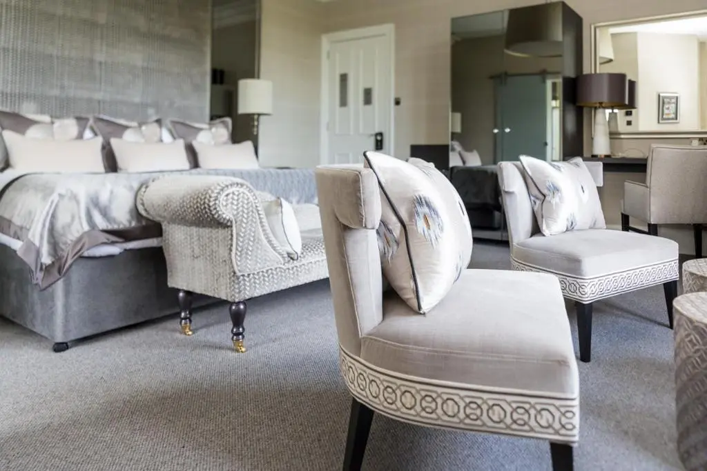 a bedroom with a bed and a couch and chairs at The Dowans Hotel of Speyside in Aberlour