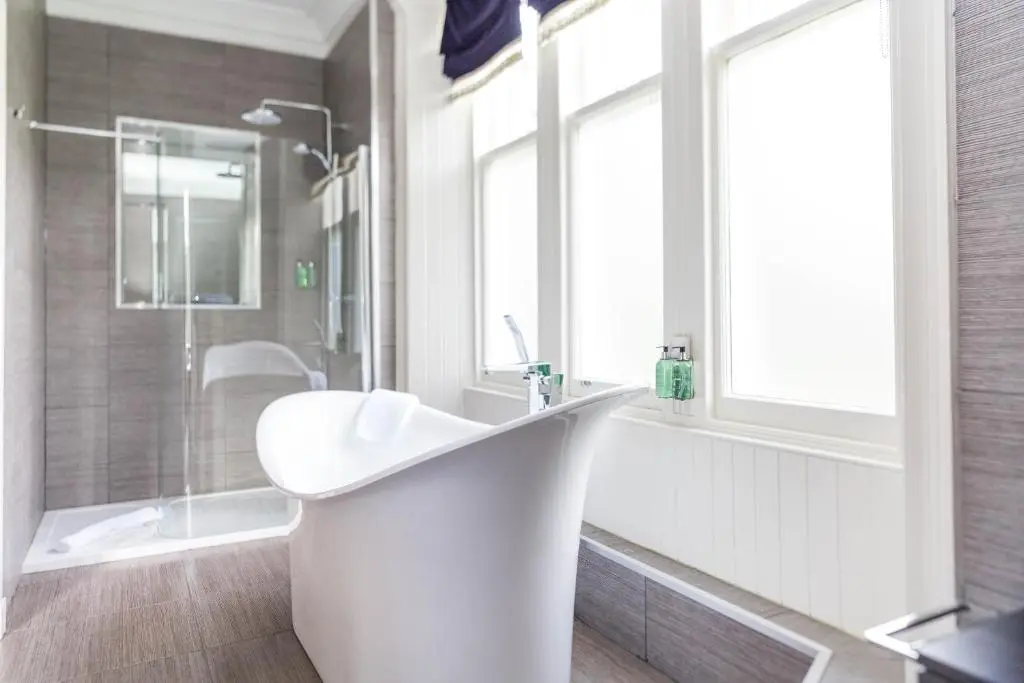 a white bathroom with a sink and a shower at The Dowans Hotel of Speyside in Aberlour
