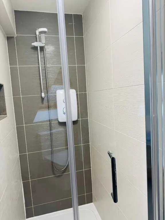 a shower with a glass door in a bathroom at The Milton Accommodation in Elgin