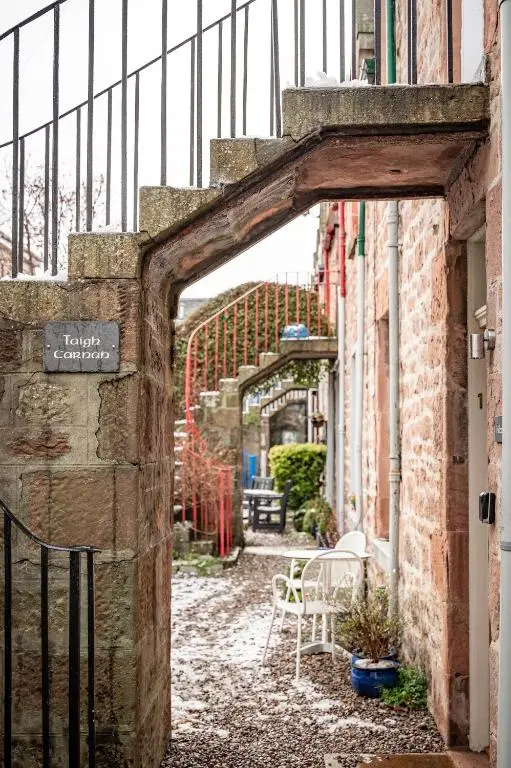 an archway in an alley with a table and chairs at Taigh Carnan in Inverness