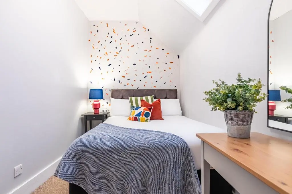 a small bedroom with a bed and a desk at Taigh Carnan in Inverness
