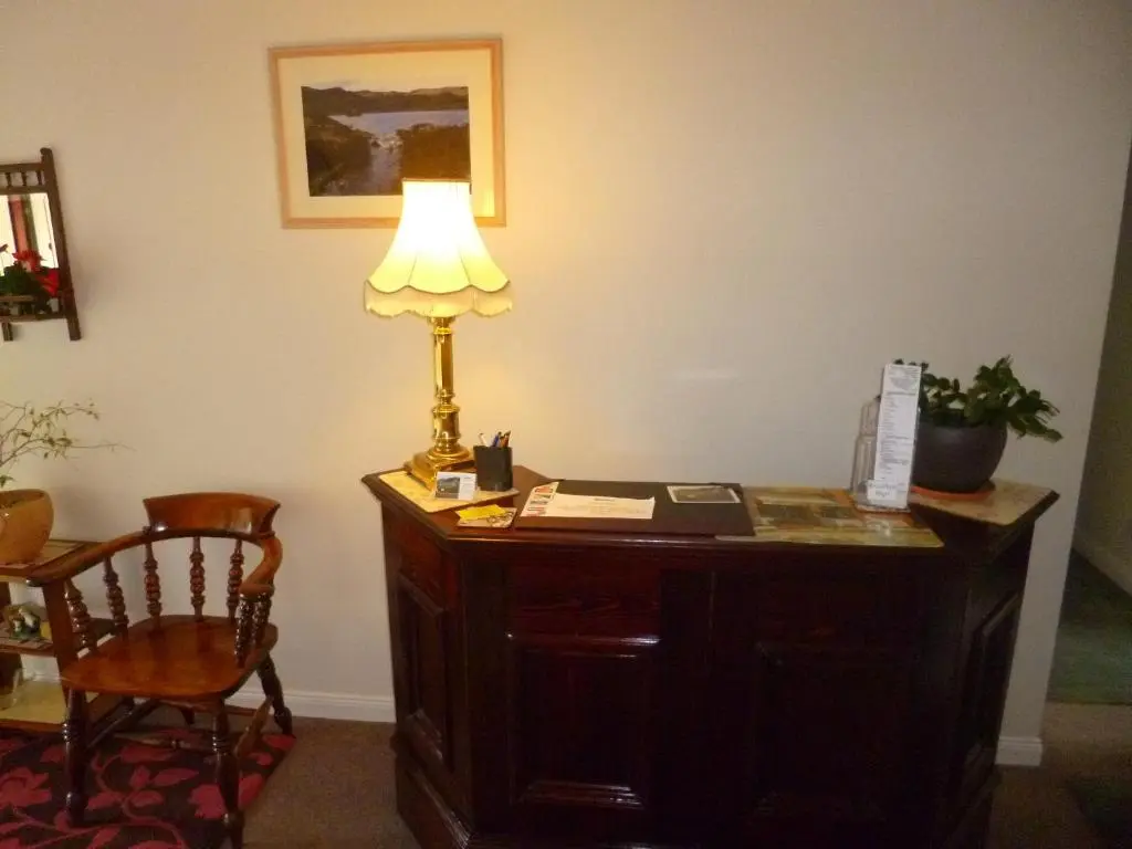 a desk with a lamp and a chair in a room at Aslaich in Drumnadrochit