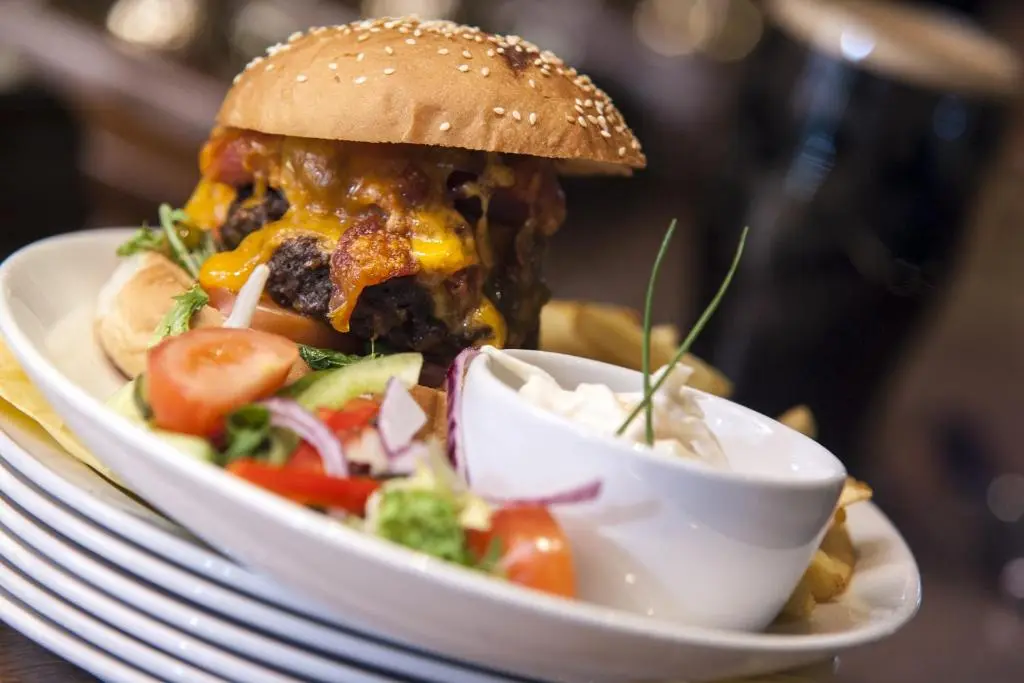 a sandwich on a plate with a salad in a bowl at The Glen Hotel Newtonmore - Rooms, bar & restaurant in Newtonmore