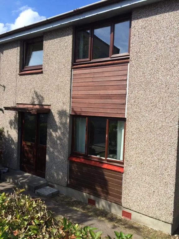 a house with a wooden door and windows at Invermac House in Inverness