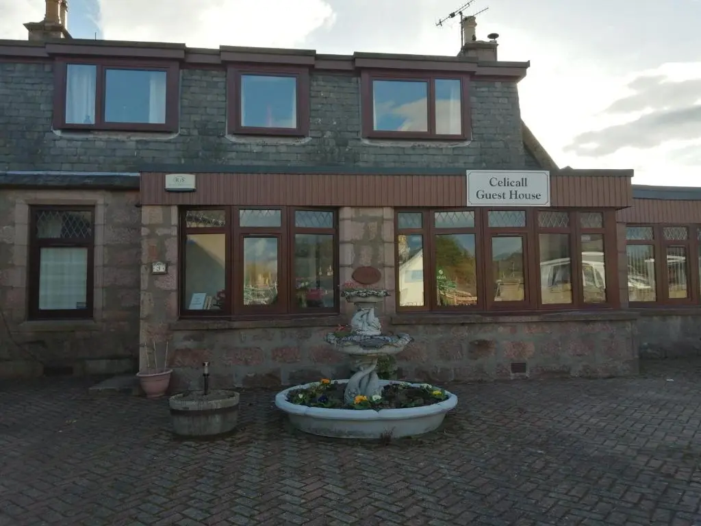 a building with a fountain in front of a building at Celicall in Ballater