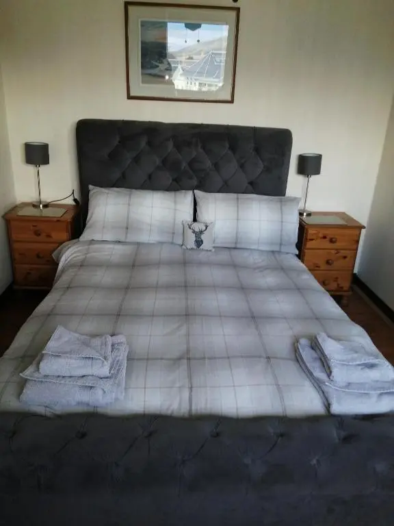 a bedroom with a large bed with towels on it at Celicall in Ballater