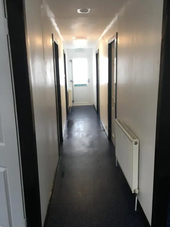 a hallway of an office building with doors and a window at Ledgowan Bunkhouse in Achnasheen