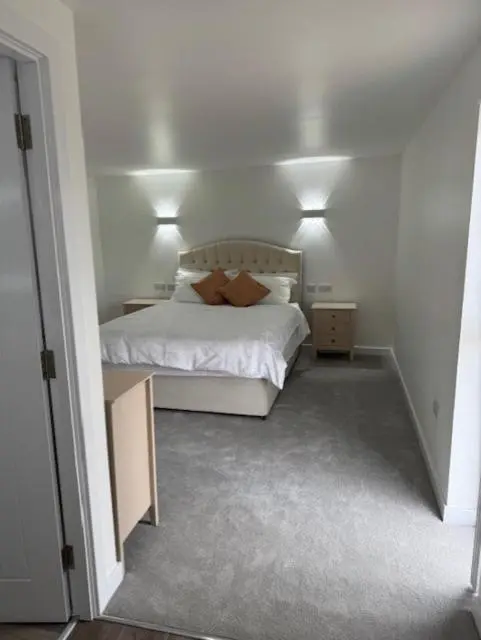 a bedroom with a white bed with two pillows at Ledgowan Bunkhouse in Achnasheen