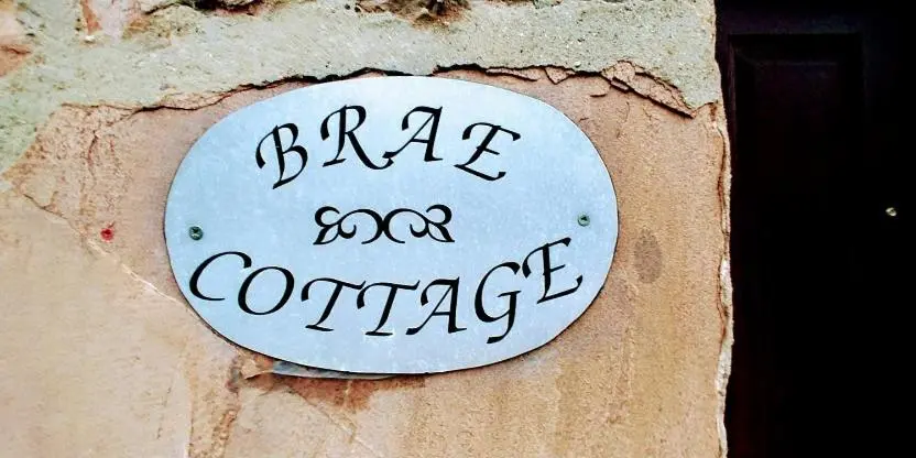 a sign on a wall that says dance and converge at Brae Cottage, Inverness in Inverness