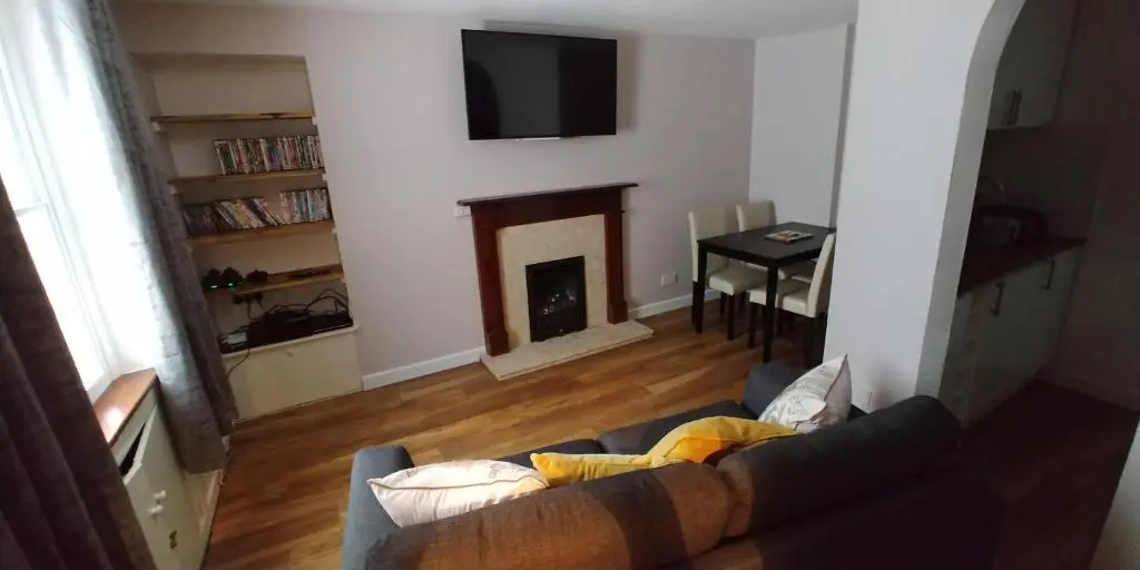 a living room with a couch and a fireplace at Brae Cottage, Inverness in Inverness