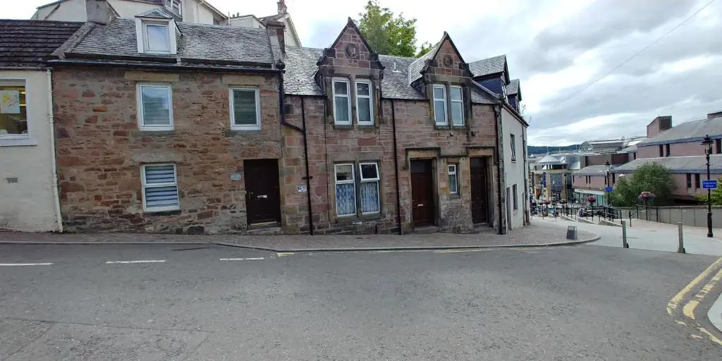 an old brick building on the side of a street at Brae Cottage, Inverness in Inverness