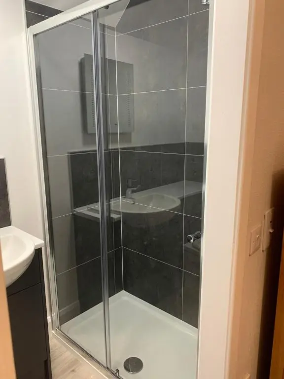 a glass shower in a bathroom with a sink at Eastdene Guest House in Inverness