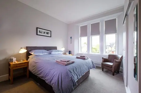 a bedroom with a large bed and a chair at Eastdene Guest House in Inverness