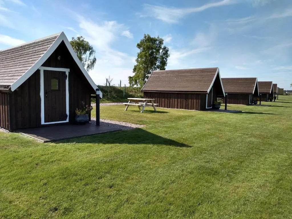 a group of cottages with a picnic table in a field at Macbeth's Hillock in Forres