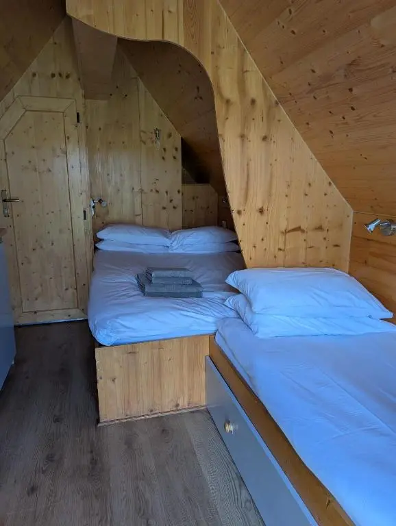 a room with two beds in a wooden cabin at Macbeth's Hillock in Forres