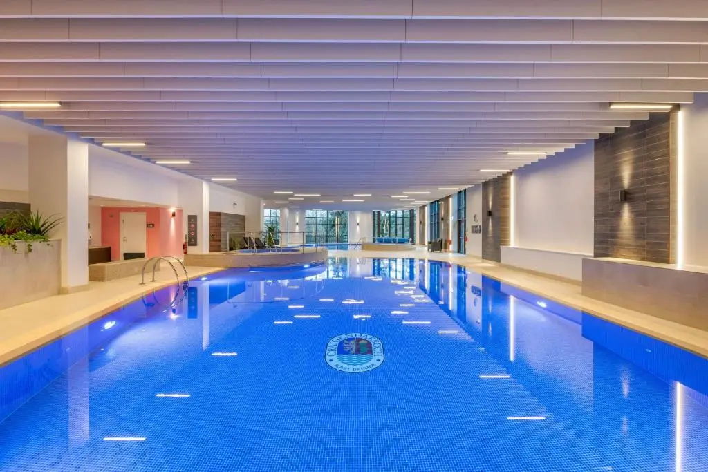 a large swimming pool with blue water in a building at Hilton Grand Vacations Club Craigendarroch Suites Scotland in Ballater
