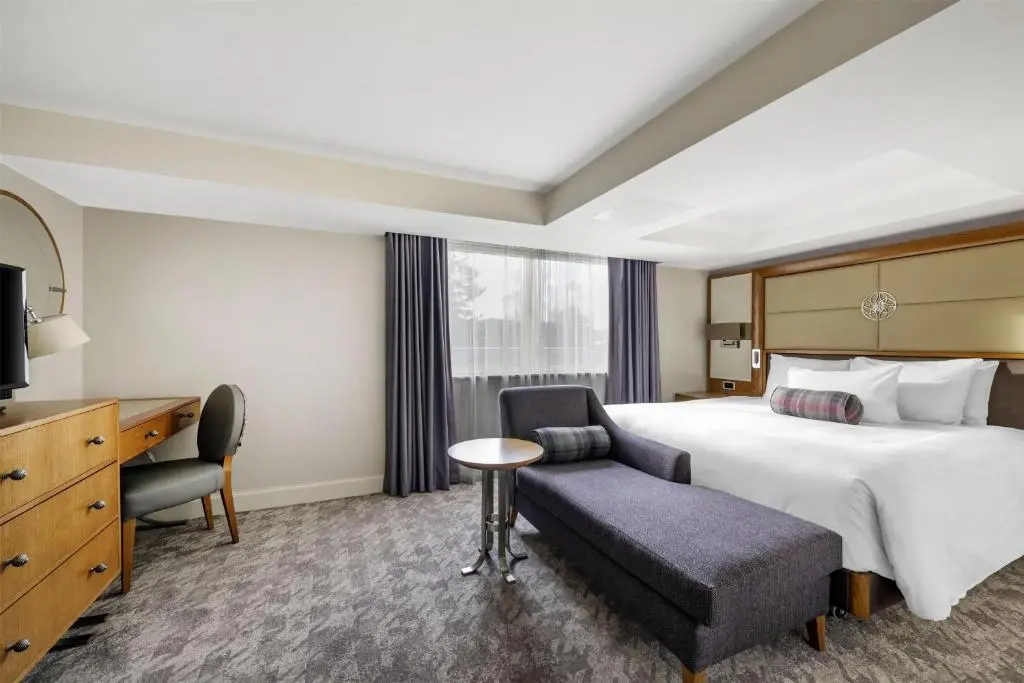 a hotel room with a bed and a chair and a tv at Hilton Grand Vacations Club Craigendarroch Suites Scotland in Ballater