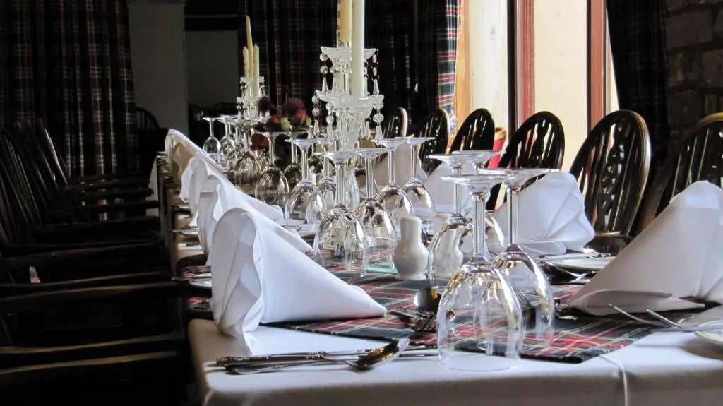 a table with white napkins and glasses on it at Loch Ness Lodge Hotel in Drumnadrochit