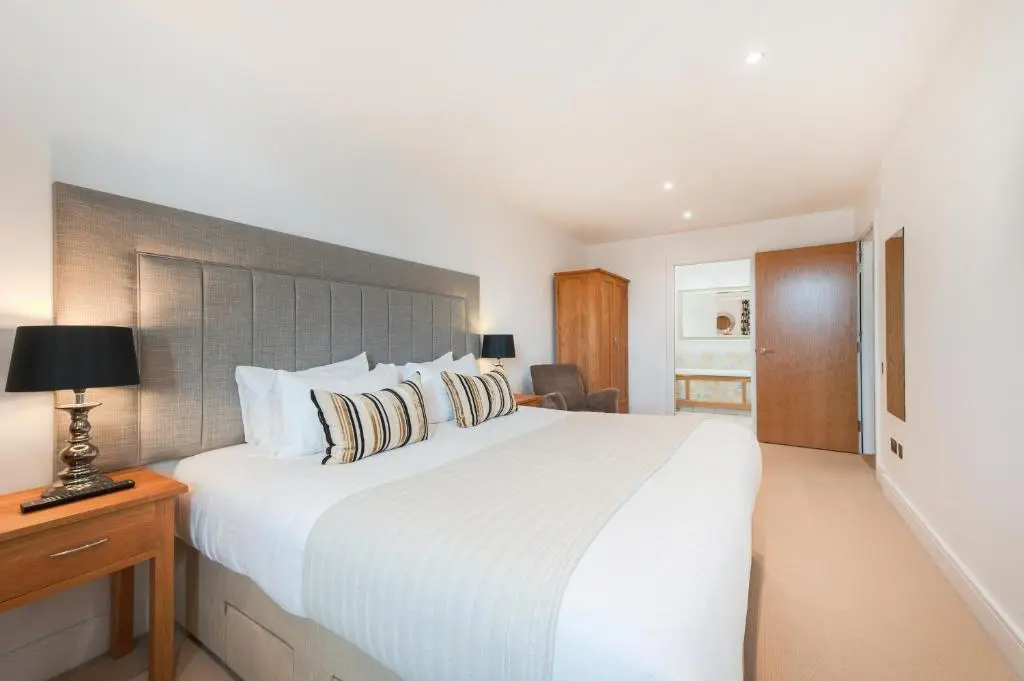 a bedroom with a large white bed and a desk at Highland Apartments by Mansley in Inverness