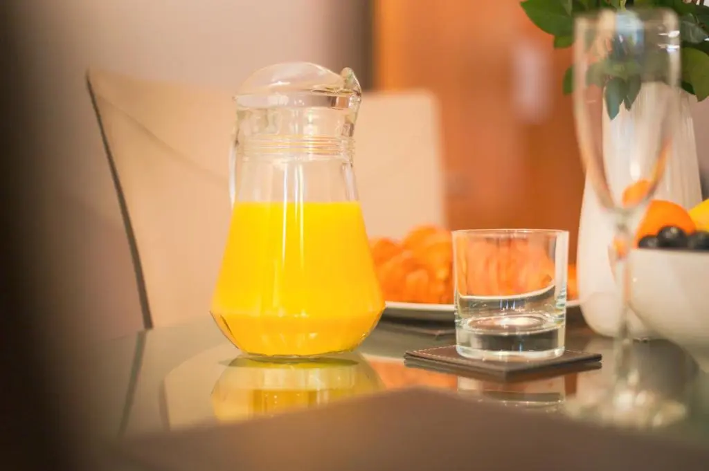a bottle of orange juice and a glass of water on a table at Highland Apartments by Mansley in Inverness