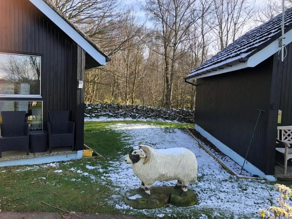 a statue of a sheep in the yard of a house at Kilcoy Chalets in Muir of Ord