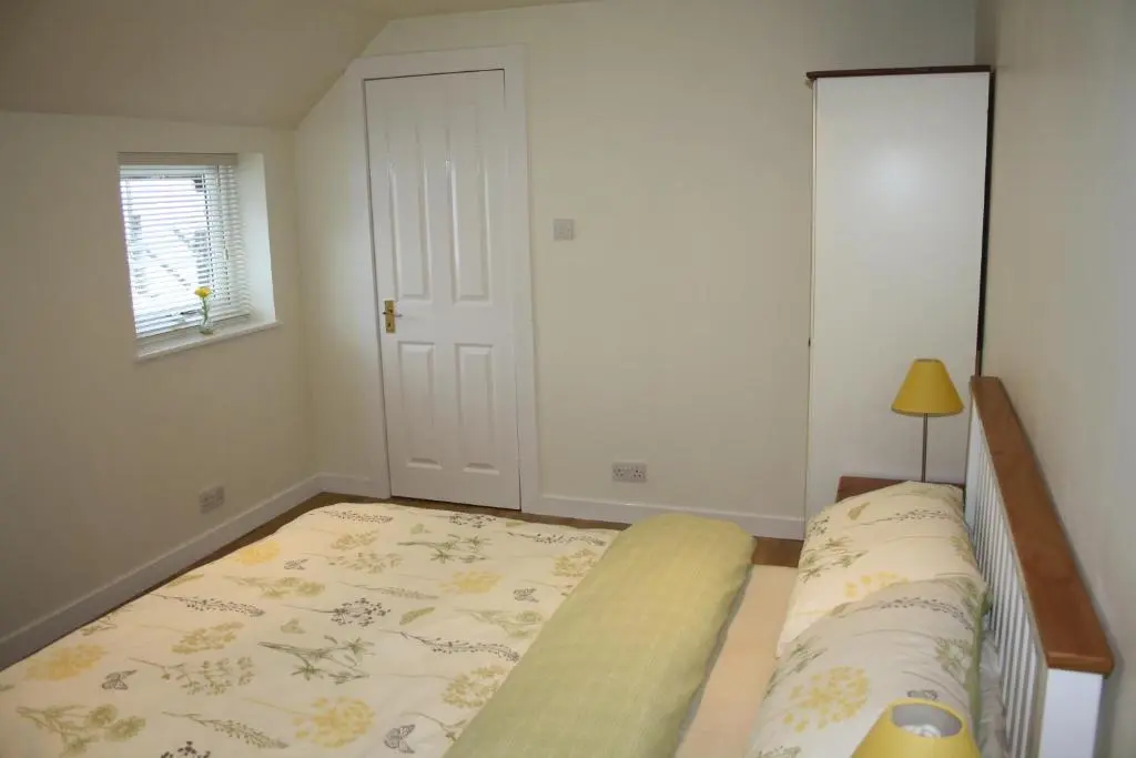 a small bedroom with a bed and a window at Ardgarry Farm in Invergarry