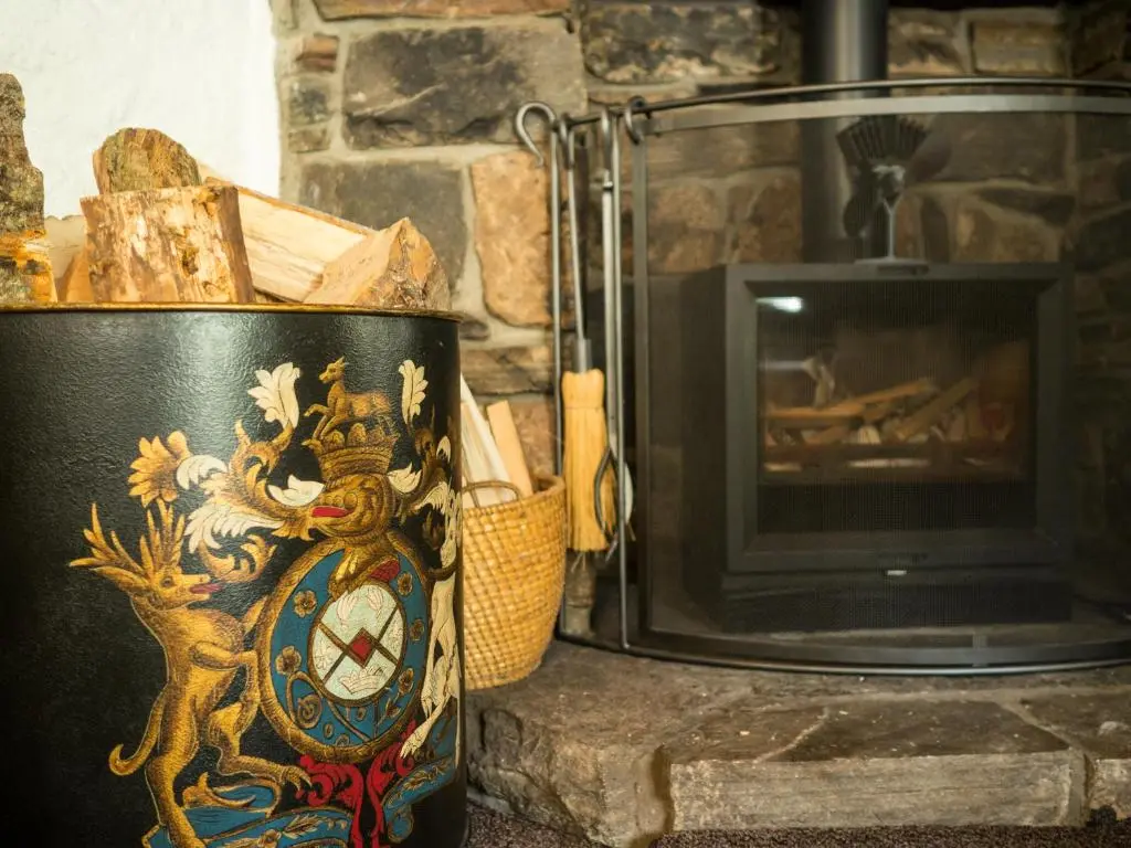a pot sitting in front of a fireplace next to a stove at Coylumbridge Cottage in Aviemore