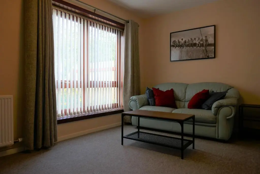a living room with a couch and a table and a window at Inverness Family House in Inverness