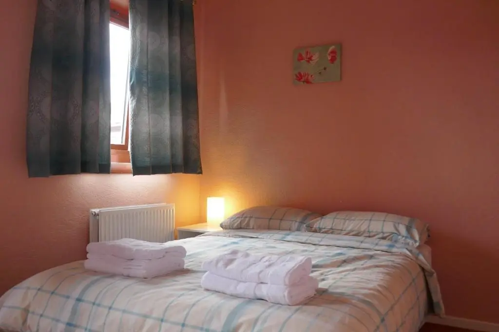 a bedroom with a bed with towels on it at Inverness Family House in Inverness