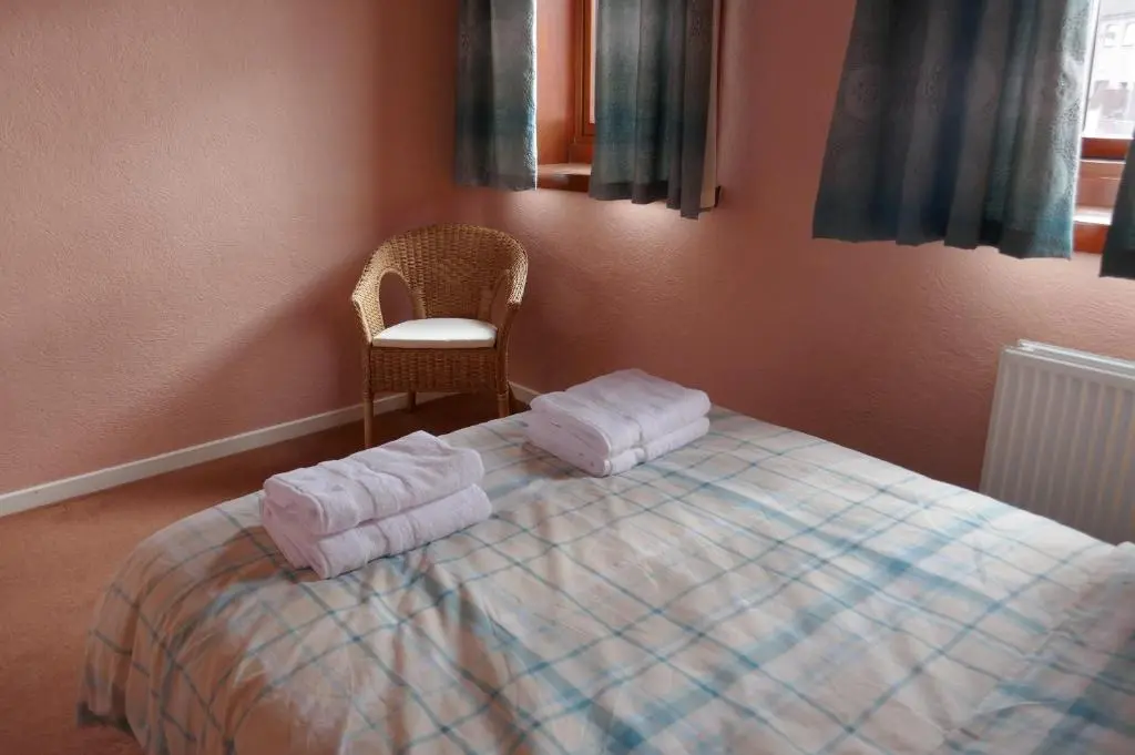 a bedroom with a bed with towels on it at Inverness Family House in Inverness