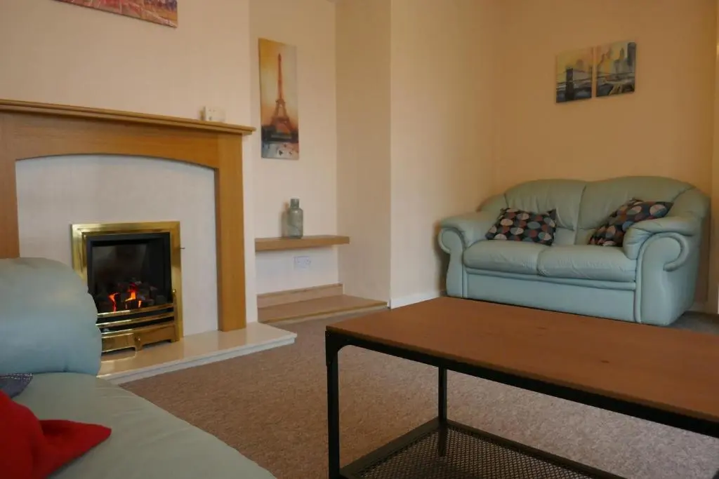 a living room with a couch and a fireplace at Inverness Family House in Inverness