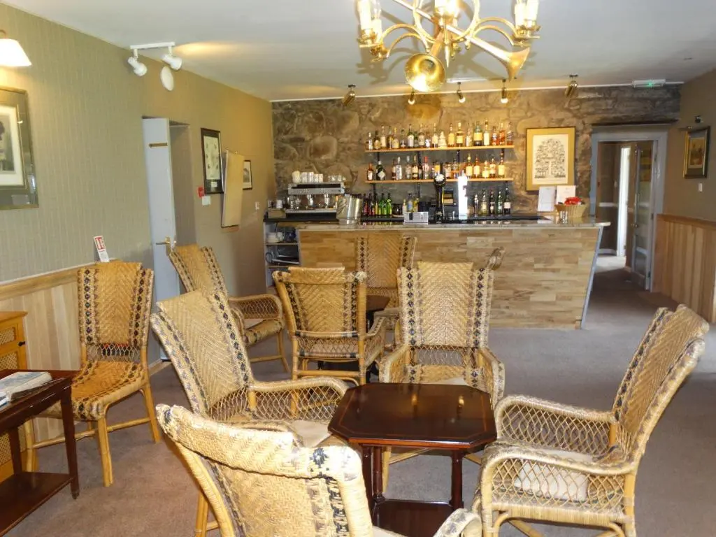 a bar in a restaurant with chairs and a table at Laggan Hotel in Laggan