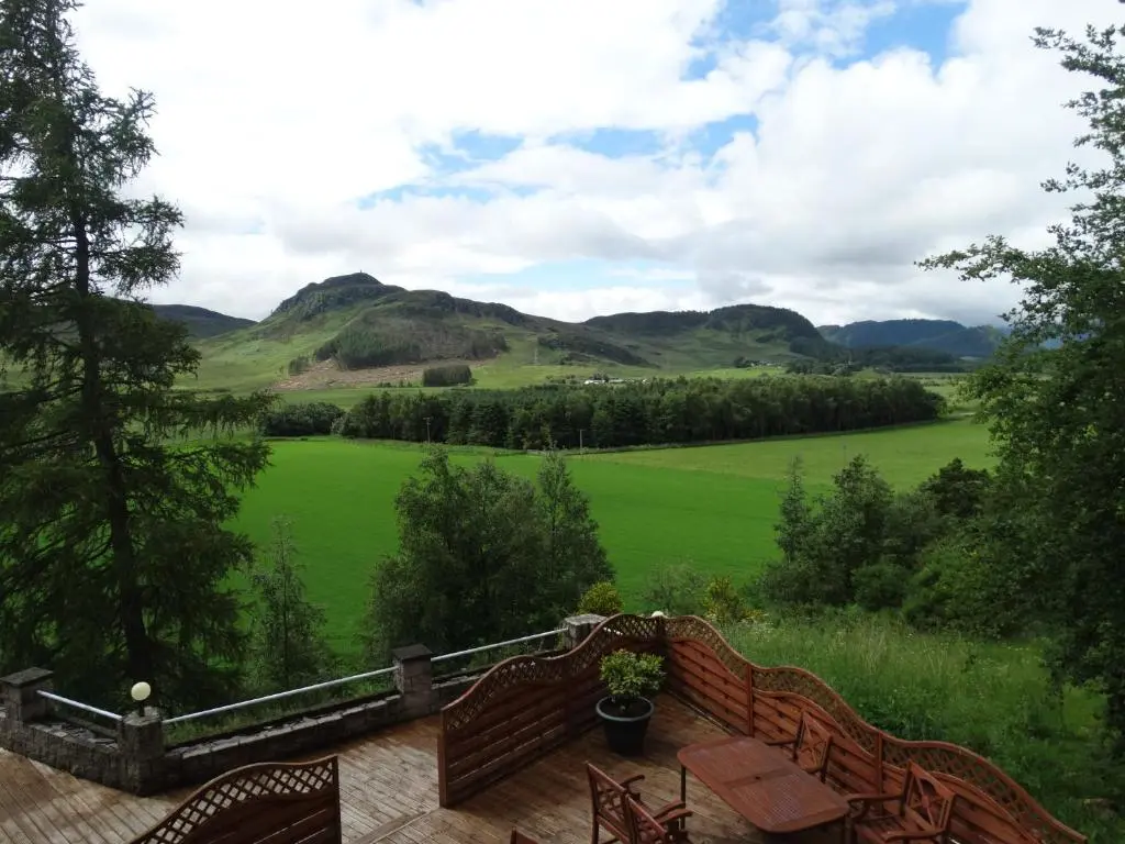 a balcony with a view of a green field at Laggan Hotel in Laggan