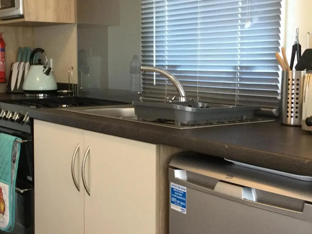 a kitchen with a sink and a counter top at Poppy Lodge in Boat of Garten