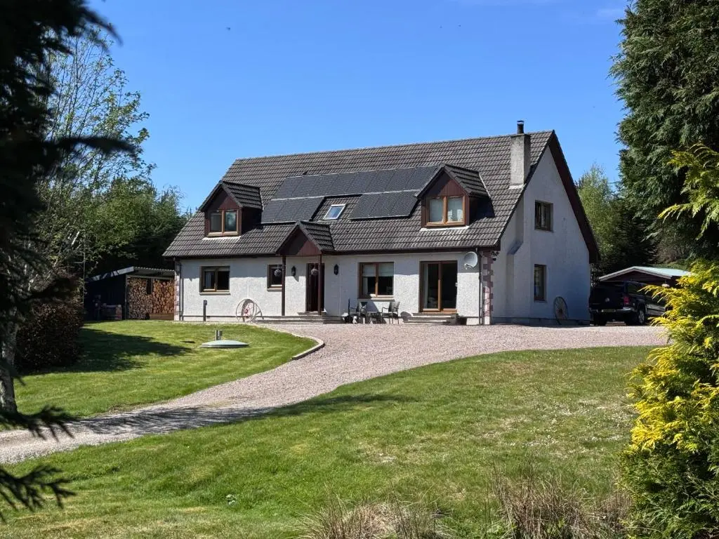 a large white house with a gravel driveway at The Garden Room Tiny House Bed and Breakfast Stay in Glenmoriston
