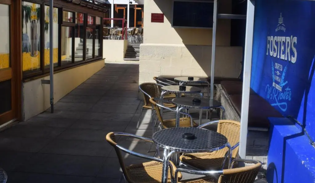 a row of tables and chairs on a sidewalk at Cheers Cafe Bar & Tavern in Fraserburgh