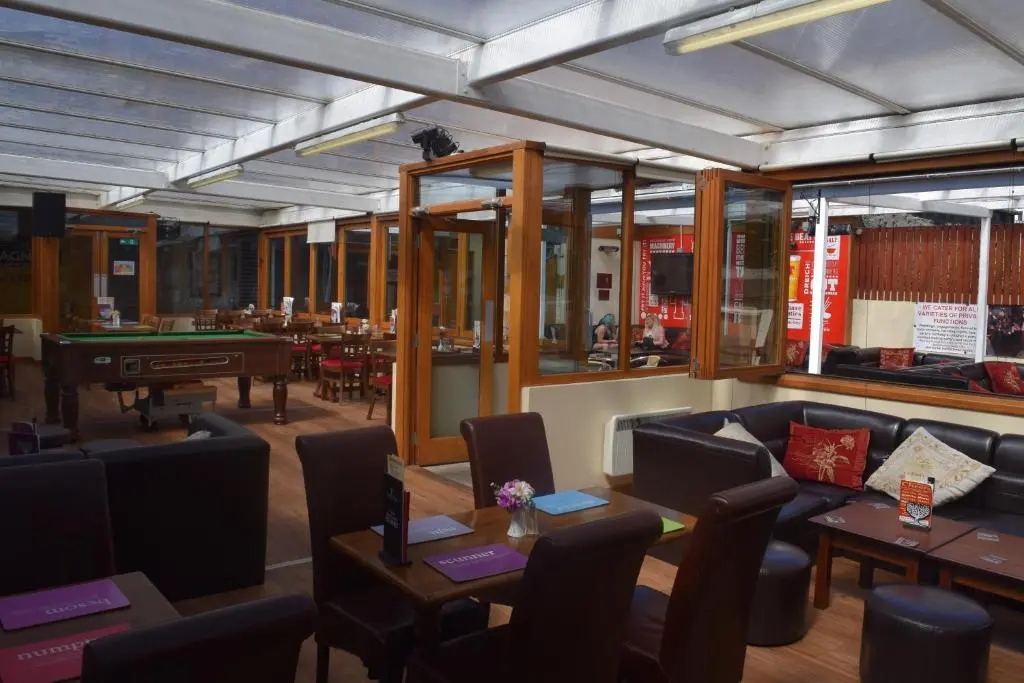 a restaurant with couches and tables and a pool table at Cheers Cafe Bar & Tavern in Fraserburgh