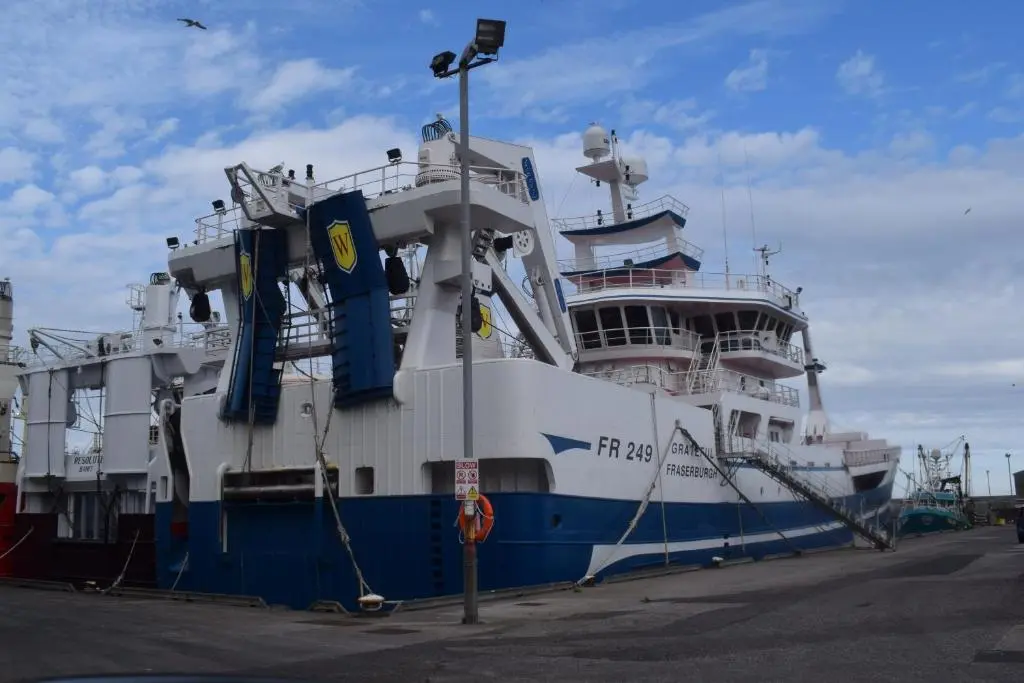 a large boat is docked at a dock at Cheers Cafe Bar & Tavern in Fraserburgh