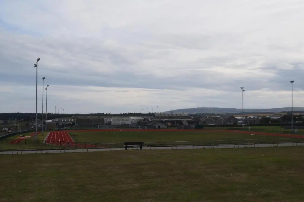 a park with a bench in the middle of a field at Cheers Cafe Bar & Tavern in Fraserburgh
