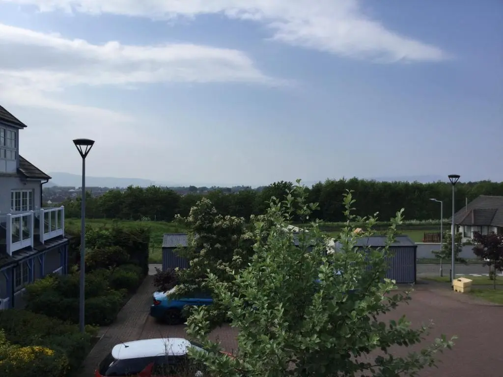 a view of a yard with a house and a car at Castlefield Apartment Free Parking in Inverness