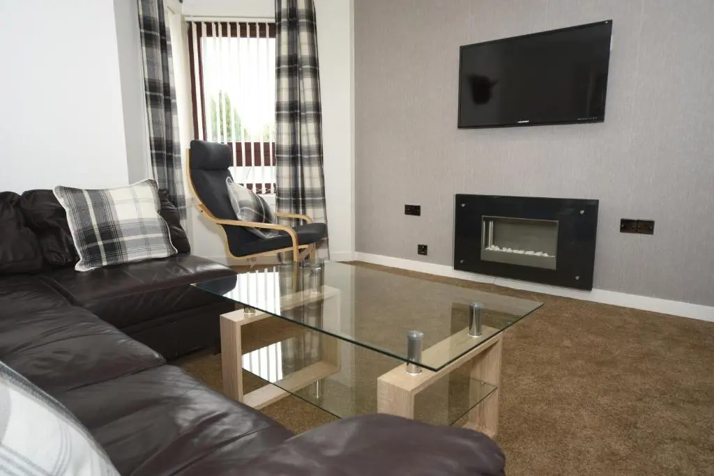 a living room with a couch and a fireplace at Silver Key Apartments in Inverness