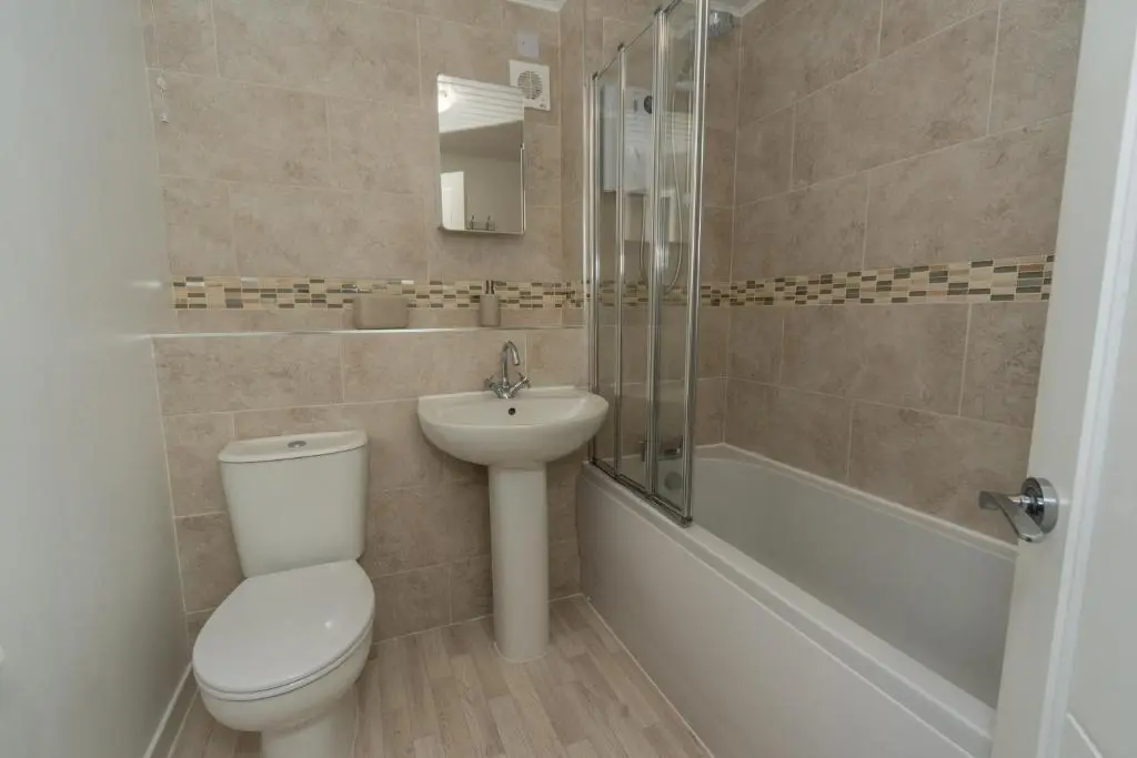 a bathroom with a toilet and a sink and a shower at Silver Key Apartments in Inverness